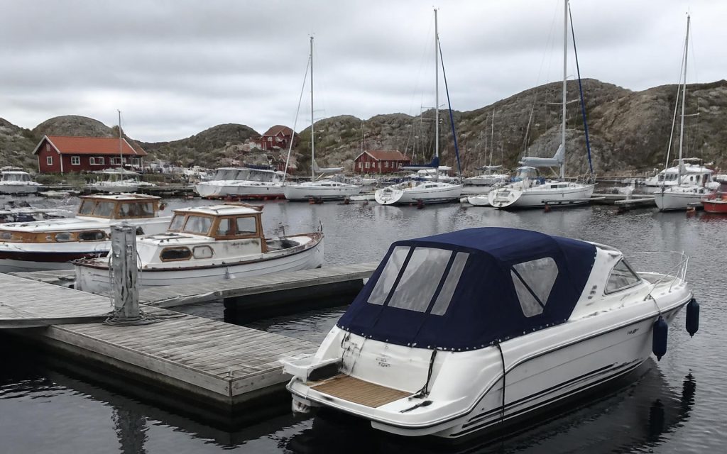 Motorbåt med blått kapell vid bryggan i en hamn utanför Göteborg